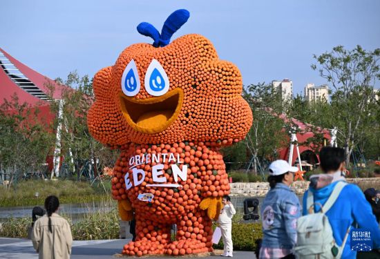 游客从一处南瓜卡通造型旁经过（10月18日摄）。